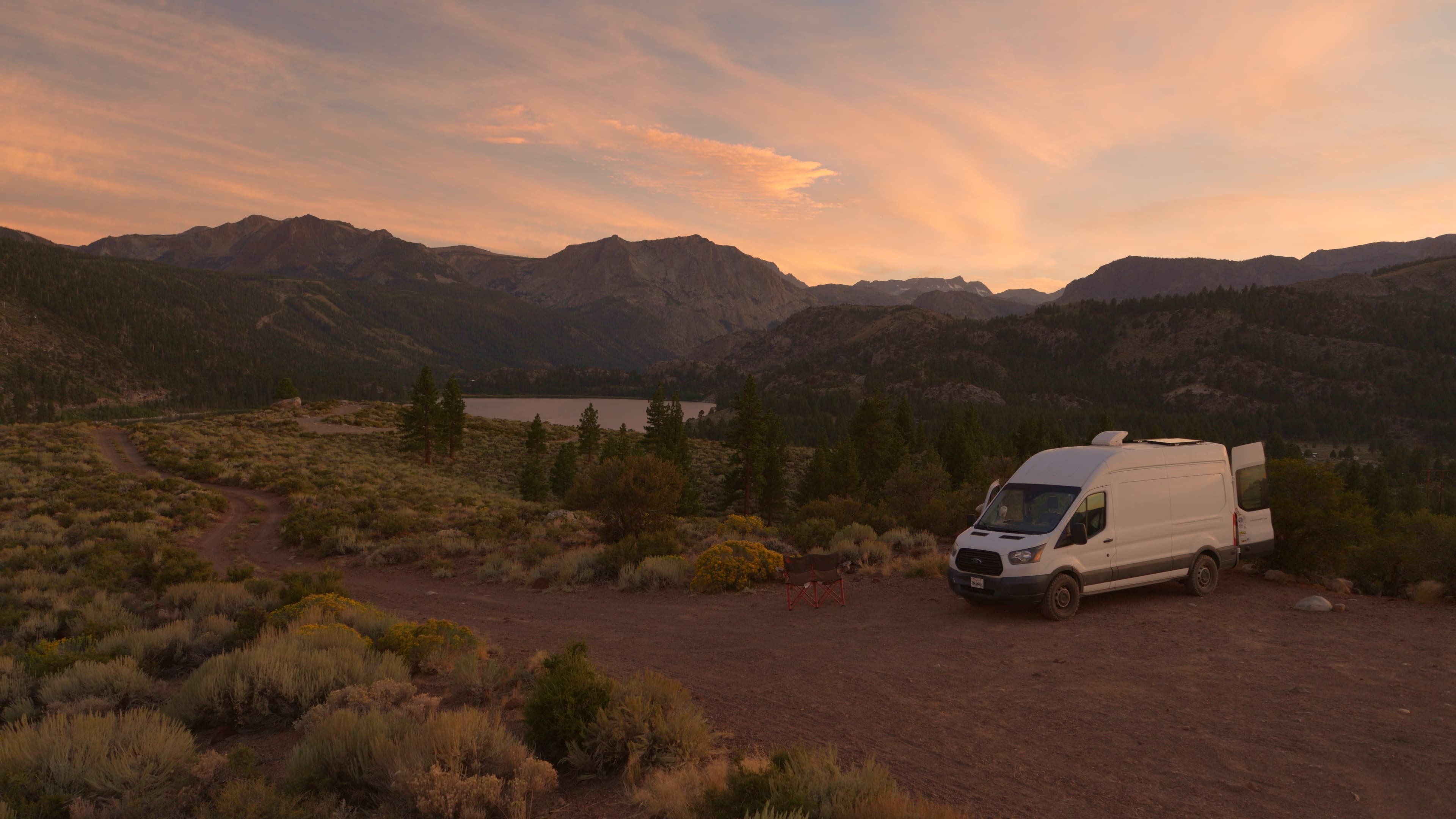 A camper van at a mountain campsite at dusk